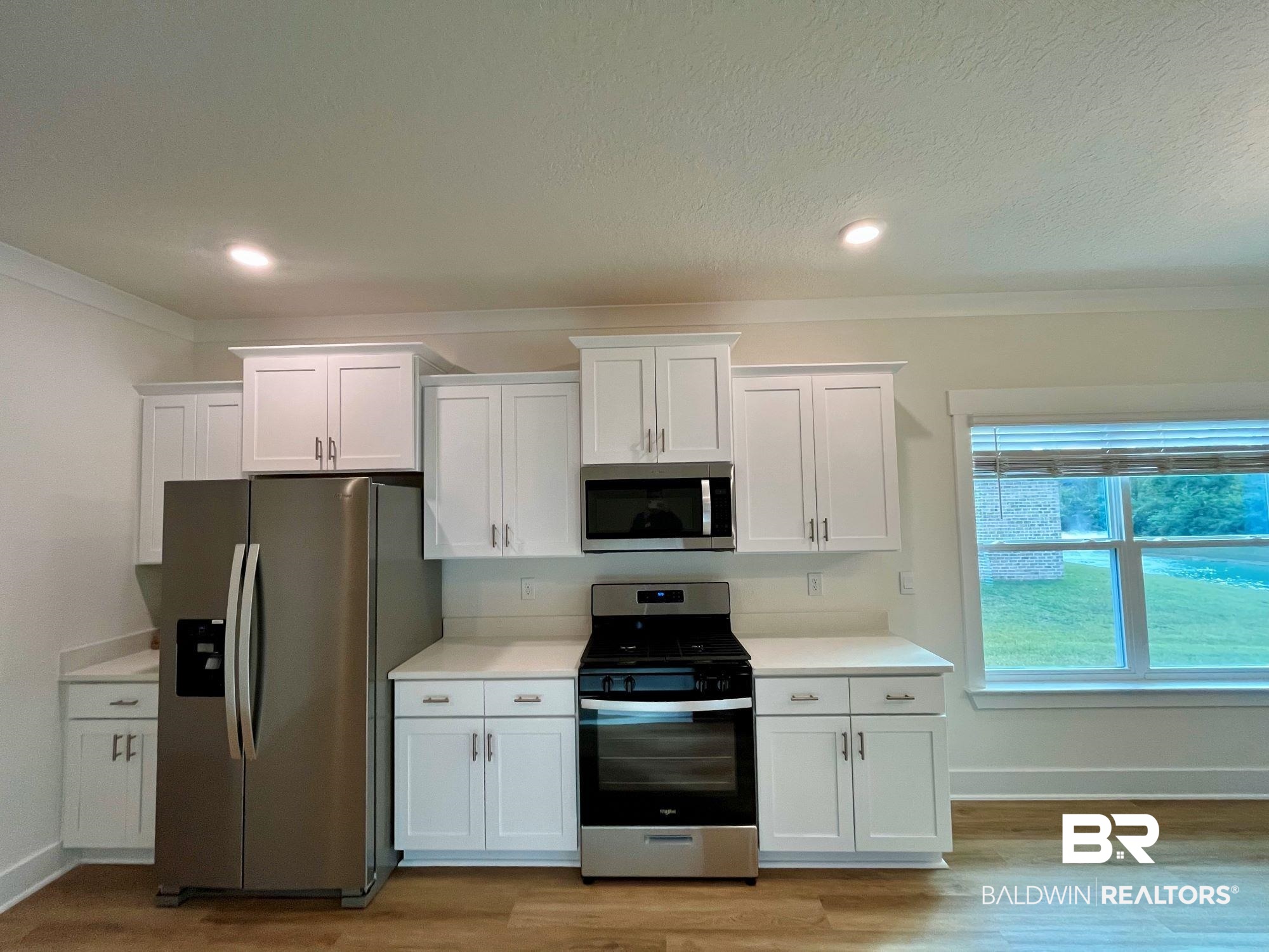 337 Barndling Street Fairhope, AL 36532 - Photo 15 of 34 Kitchen featuring white cabinets, light wood-type flooring, and stainless steel appliances