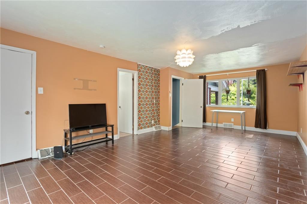 9 Woodside Road Pittsburgh, PA 15221 - Photo 14 of 24 a view of an empty room with a window and wooden floor