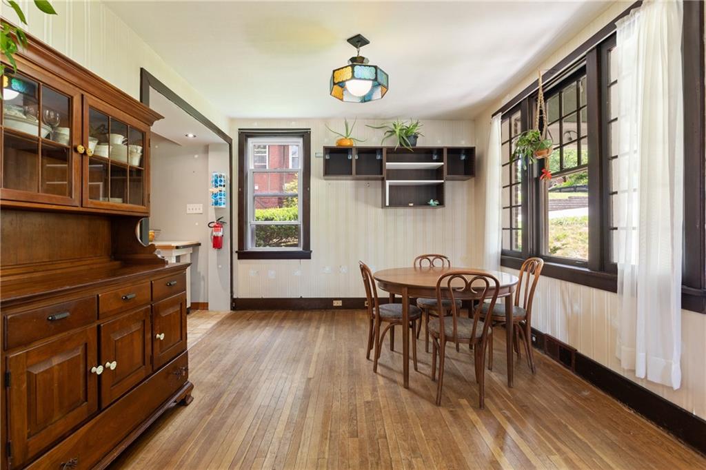 9 Woodside Road Pittsburgh, PA 15221 - Photo 5 of 24 a dining room with wooden floor a chandelier a wooden table and chairs