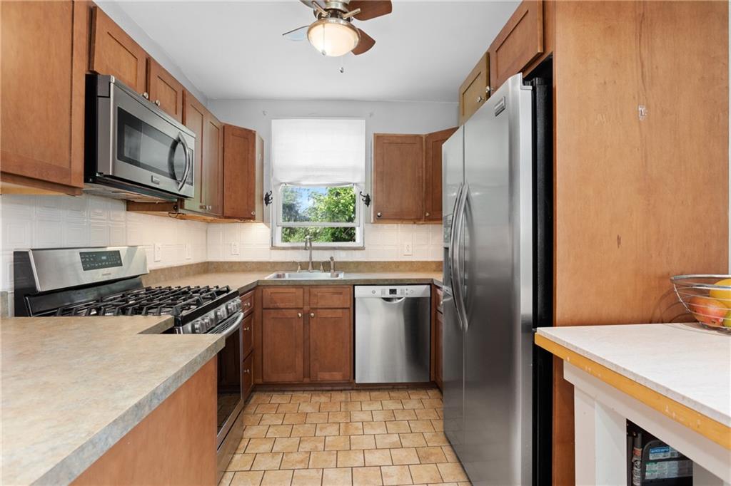 9 Woodside Road Pittsburgh, PA 15221 - Photo 7 of 24 a kitchen with stainless steel appliances granite countertop a refrigerator a stove a sink a microwave and island