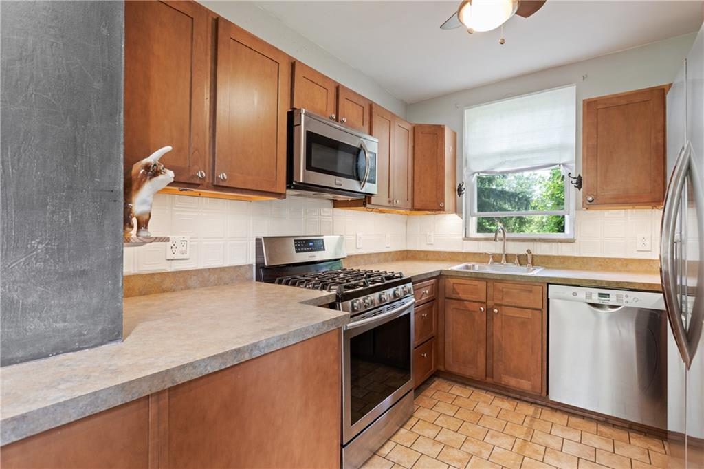 9 Woodside Road Pittsburgh, PA 15221 - Photo 8 of 24 a kitchen with stainless steel appliances granite countertop a stove a sink and a microwave