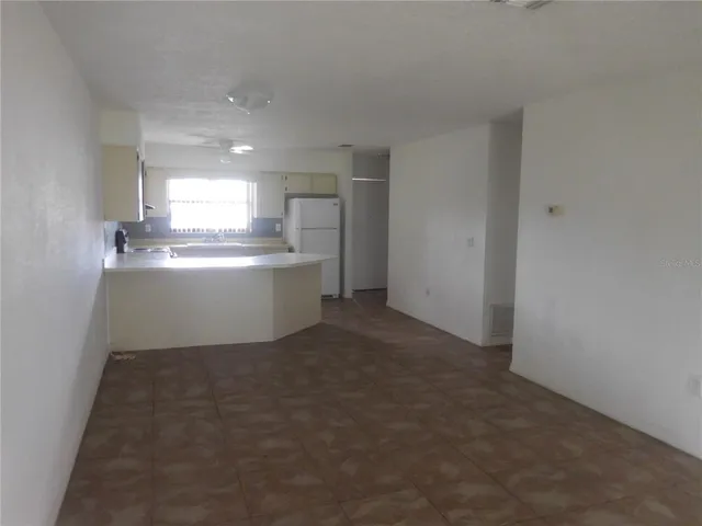 a room with kitchen island a sink stove and cabinets