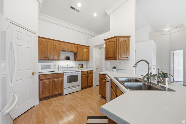 805 South River Road, Unit 70 St. George, UT 84790 - Photo 14 of 38 Kitchen featuring wood-finish flooring, light wood cabinetry, white countertops, and a double basin stainless steel sink with a high-arc faucet