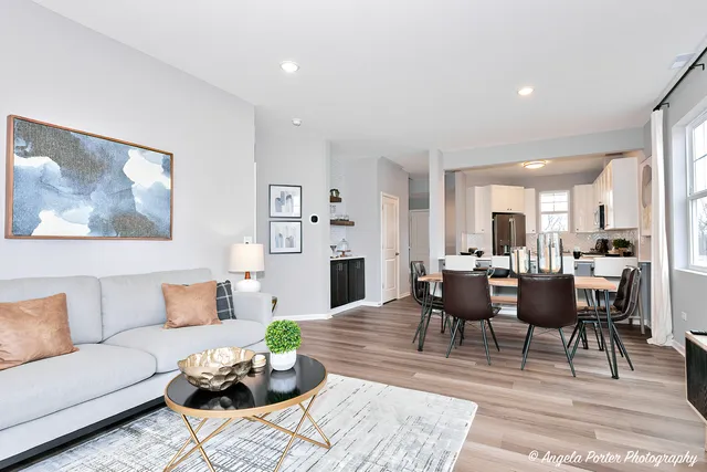 a living room with furniture dining table a lamp and a rug