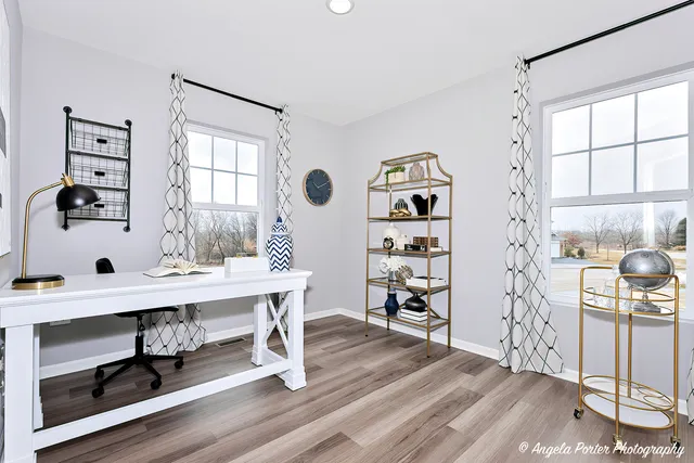 a view of a workspace with furniture and a window