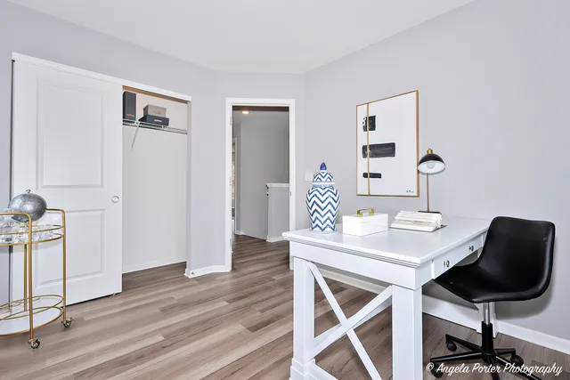 a view of a workspace with furniture and wooden floor