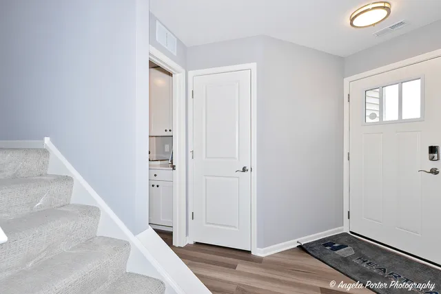 a view of hallway with window and wooden floor