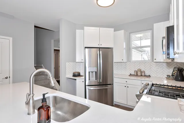a kitchen with stainless steel appliances granite countertop a sink a refrigerator and a stove