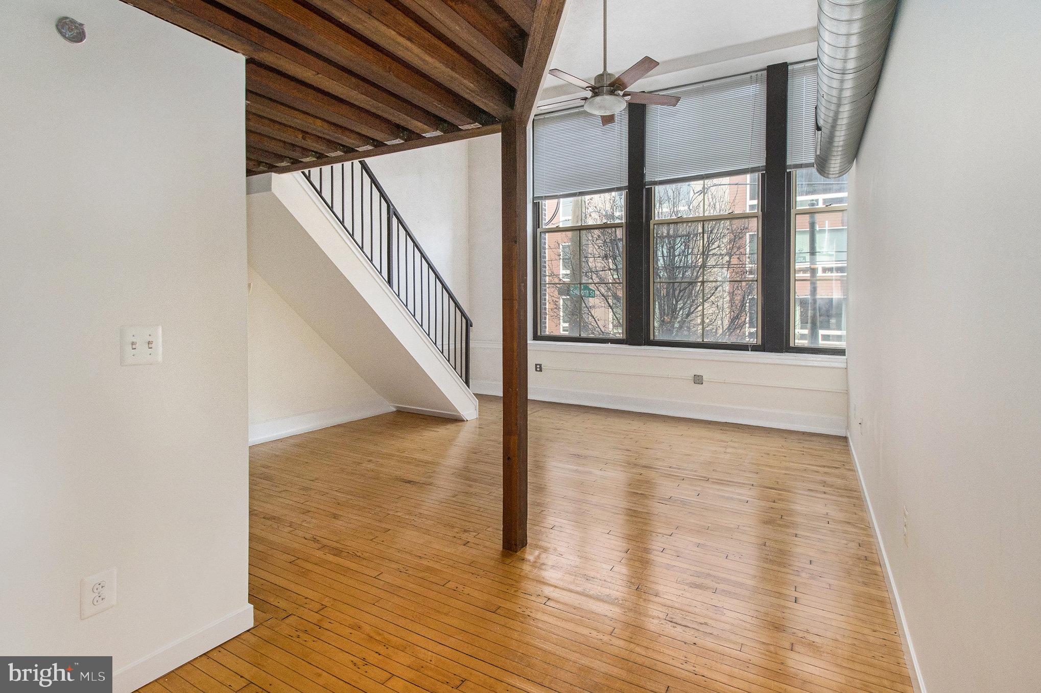 1201 Fitzwater Street, Unit 207 Philadelphia, PA 19147 - Photo 11 of 39 a view of an empty room with wooden floor and a window