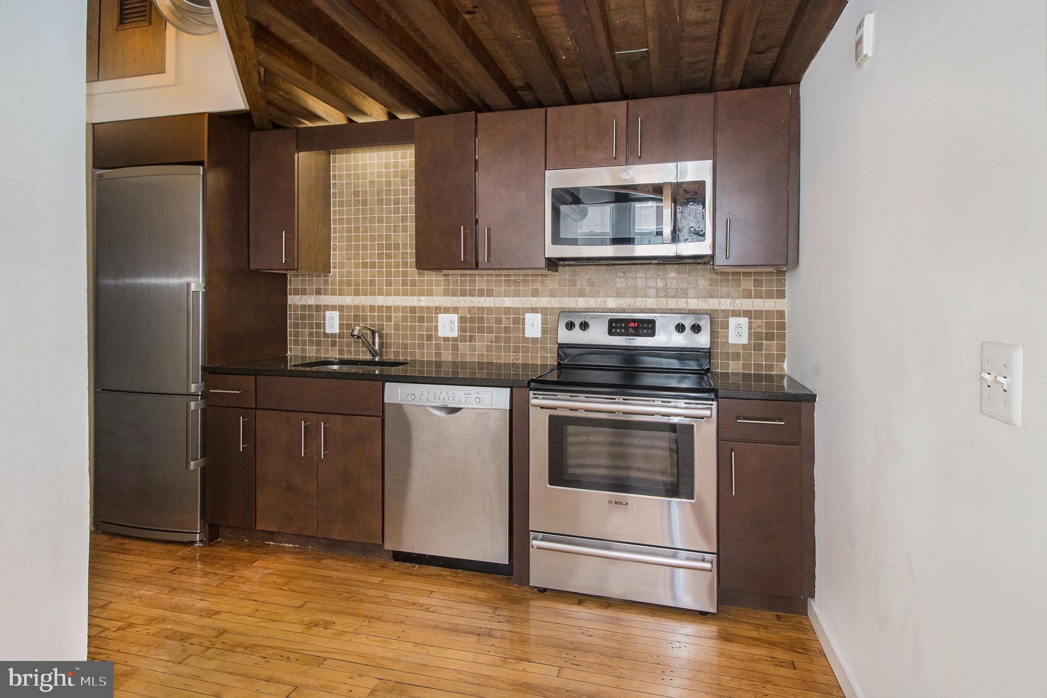 1201 Fitzwater Street, Unit 207 Philadelphia, PA 19147 - Photo 19 of 39 a kitchen with stainless steel appliances granite countertop a stove a sink and a refrigerator