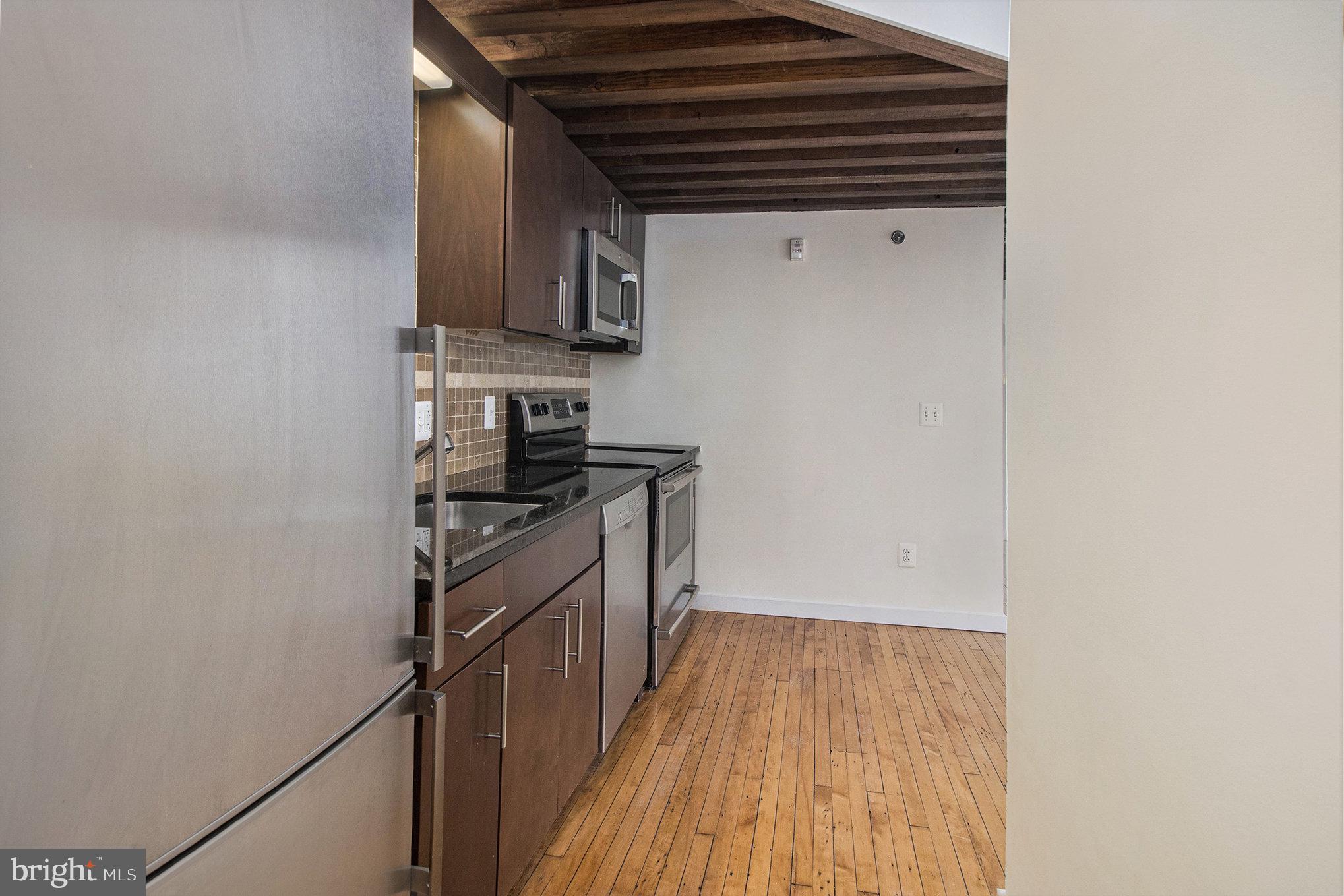 1201 Fitzwater Street, Unit 207 Philadelphia, PA 19147 - Photo 20 of 39 a kitchen with wooden floor and a stove