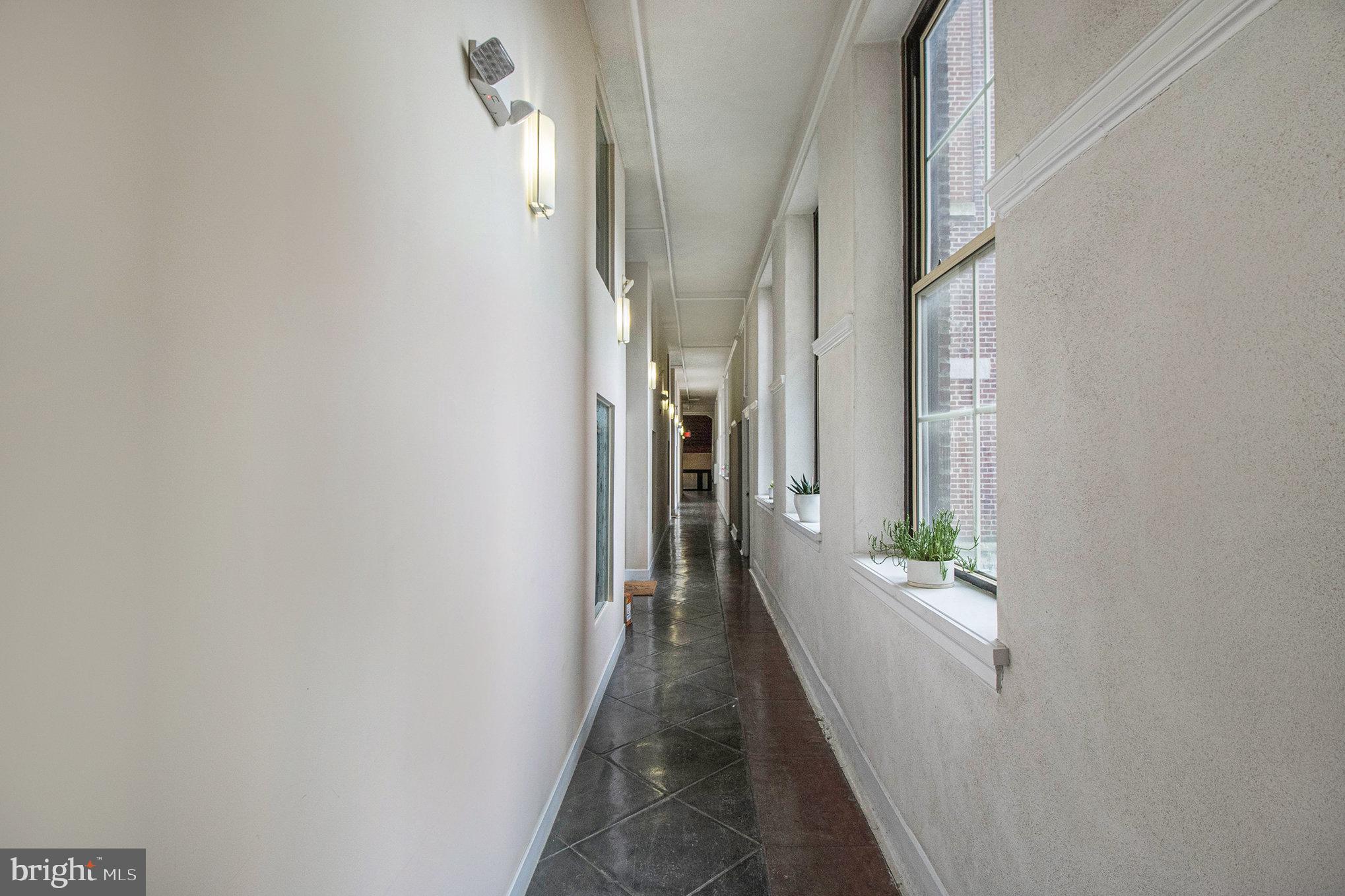 1201 Fitzwater Street, Unit 207 Philadelphia, PA 19147 - Photo 28 of 39 a view of a hallway with wooden floor and a bathroom