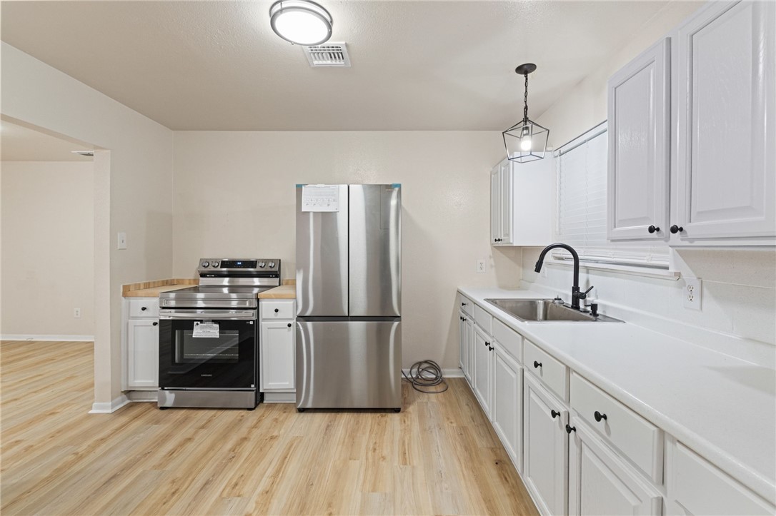 5921 Riley Drive Corpus Christi, TX 78412 - Photo 6 of 20 a kitchen with stainless steel appliances a sink cabinets and wooden floor