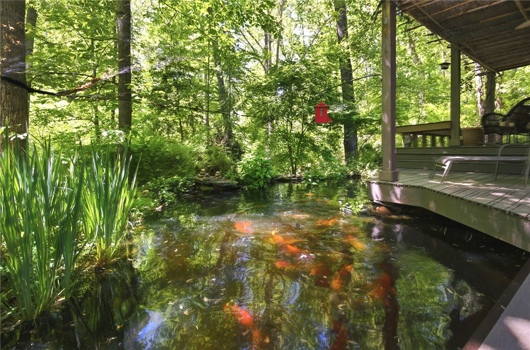 215 Inlet Pointe Drive Anderson, SC 29625 - Photo 26 of 47 This tranquil outdoor space features a serene pond and a charming deck, ideal for relaxation.