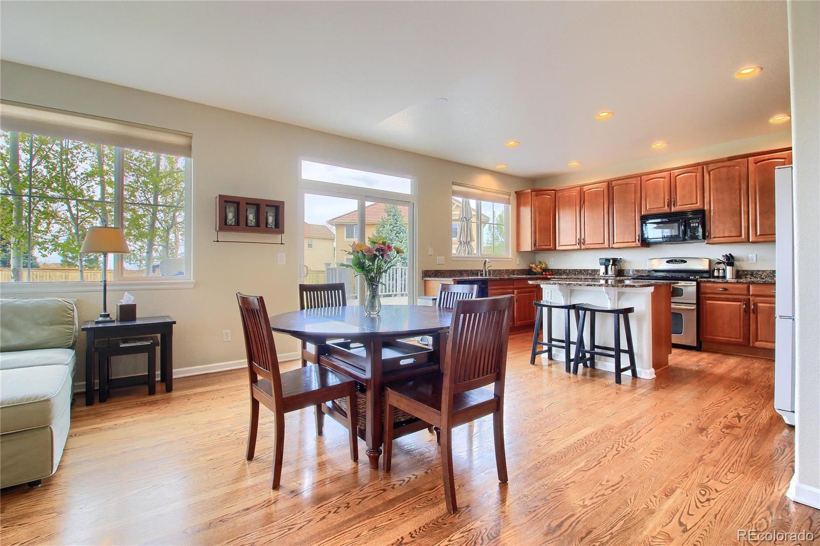 10677 Wynspire Road Highlands Ranch, CO 80130 - Photo 18 of 40 a view of a dining room with furniture and wooden floor