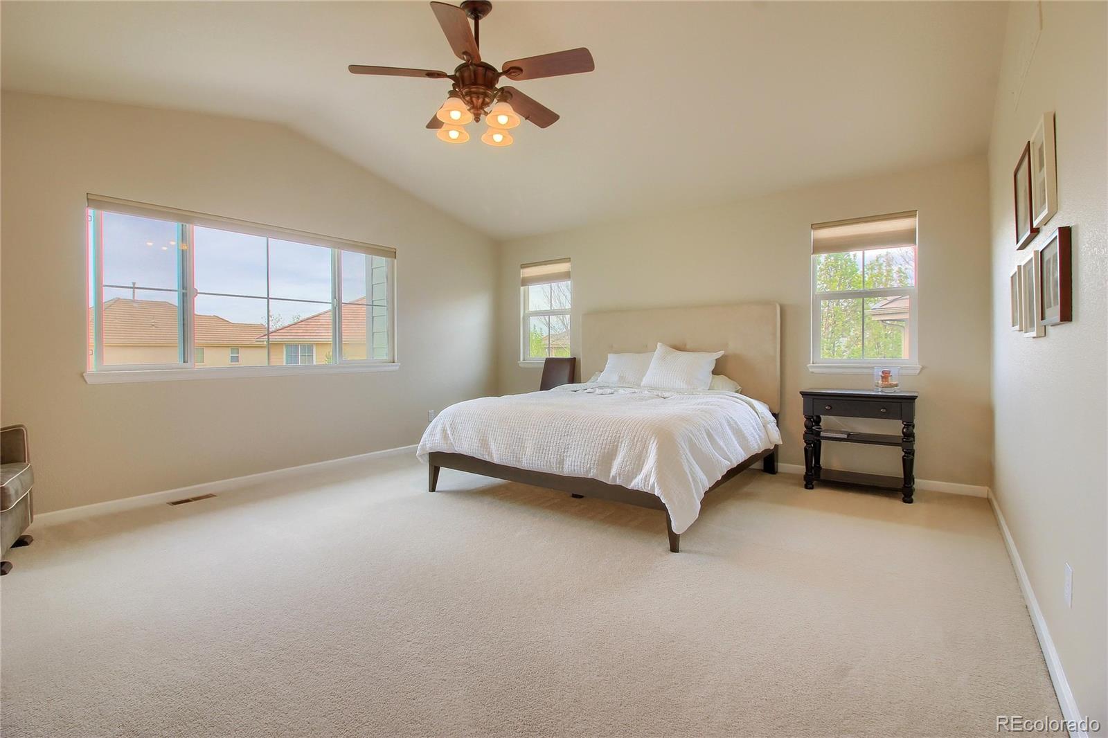 10677 Wynspire Road Highlands Ranch, CO 80130 - Photo 21 of 40 a bedroom with a bed chandelier and a window
