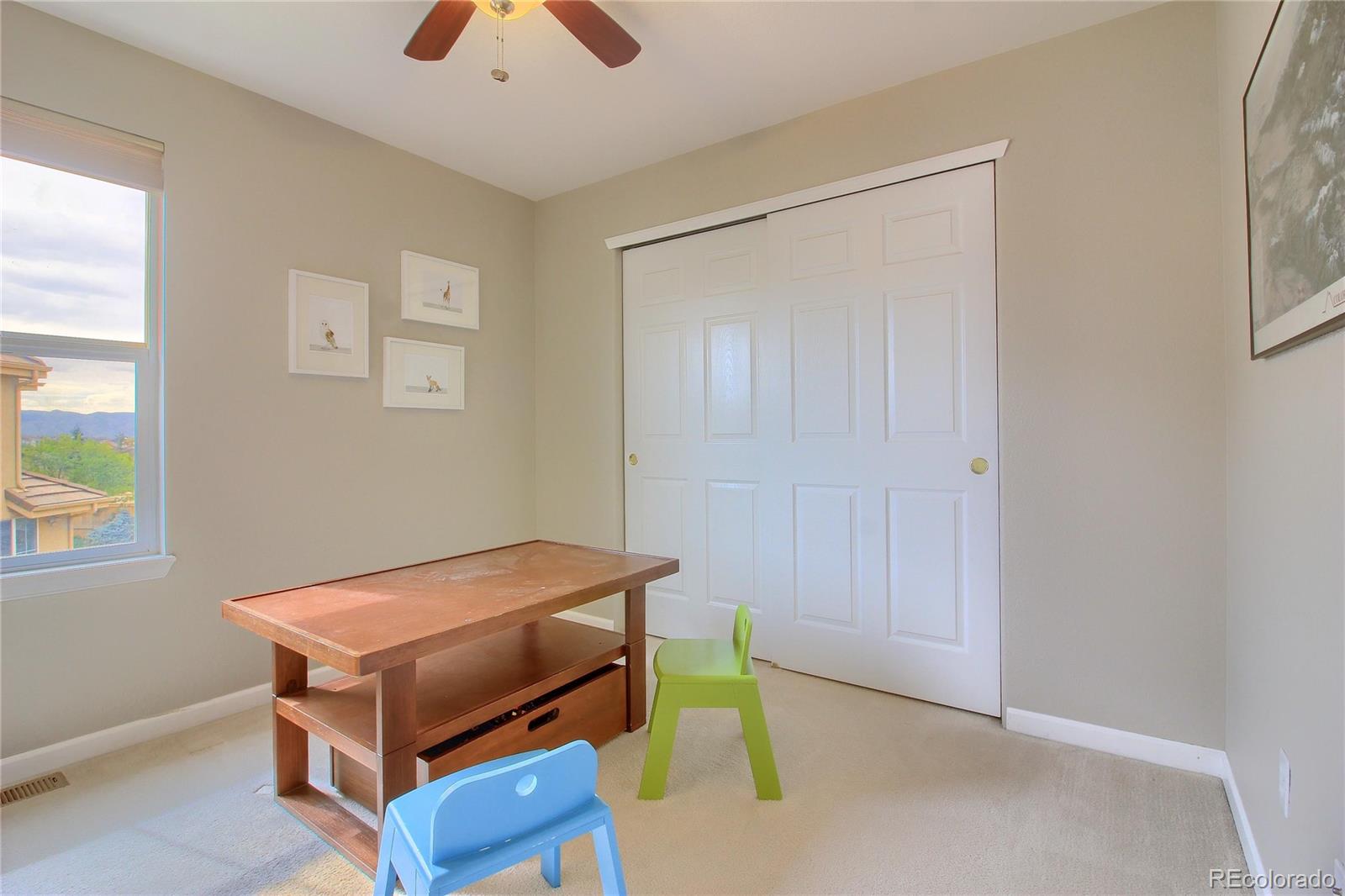 10677 Wynspire Road Highlands Ranch, CO 80130 - Photo 28 of 40 a room with a bed and a chandelier fan