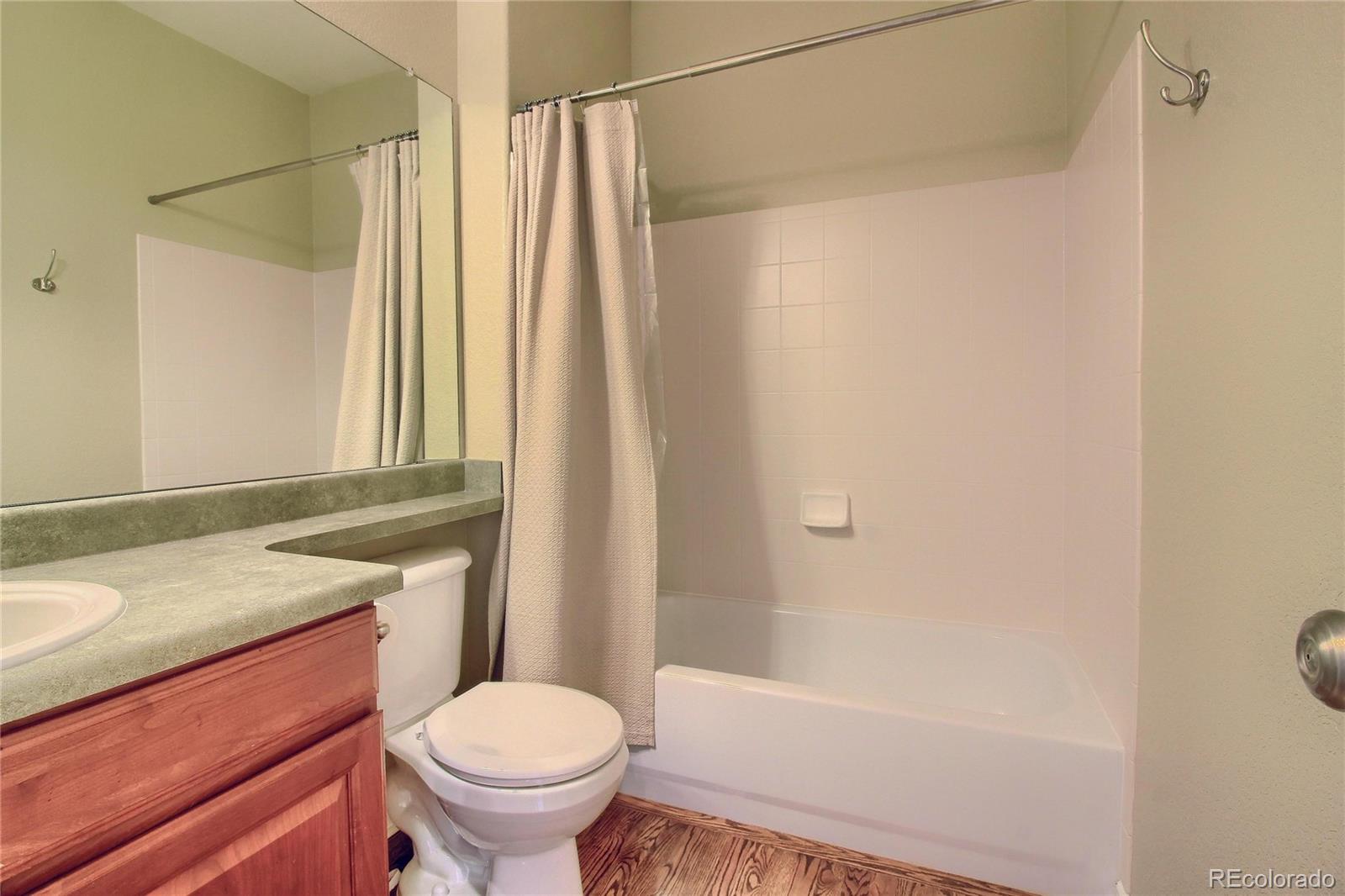 10677 Wynspire Road Highlands Ranch, CO 80130 - Photo 32 of 40 a bathroom with a granite countertop sink toilet and shower