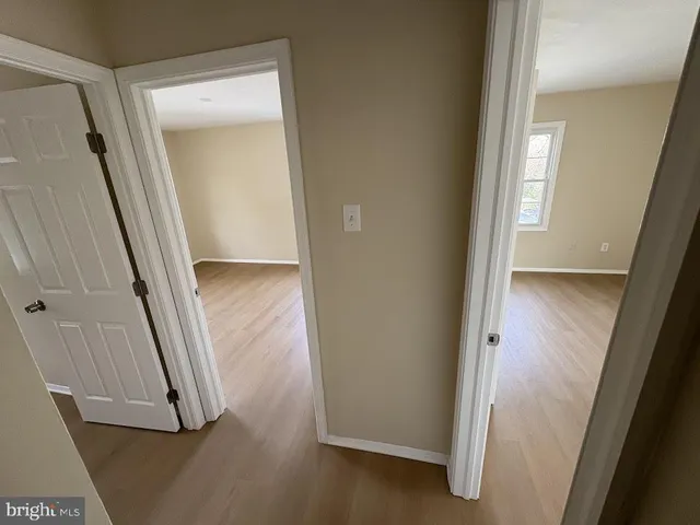 an entryway with wooden floor and a mirror