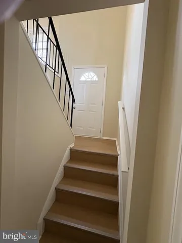 a view of staircase with wooden floor and white walls