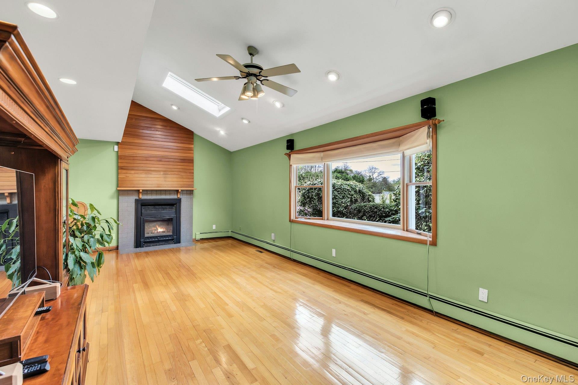 8 Adelphi Street Islip, NY 11751 - Photo 4 of 38 Living Room with Wood Burning Fireplace and Cathedral Ceiling with 2 Skylights.