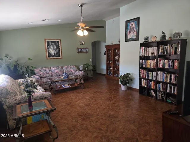 a living room with furniture hard wood floor and a bookshelf