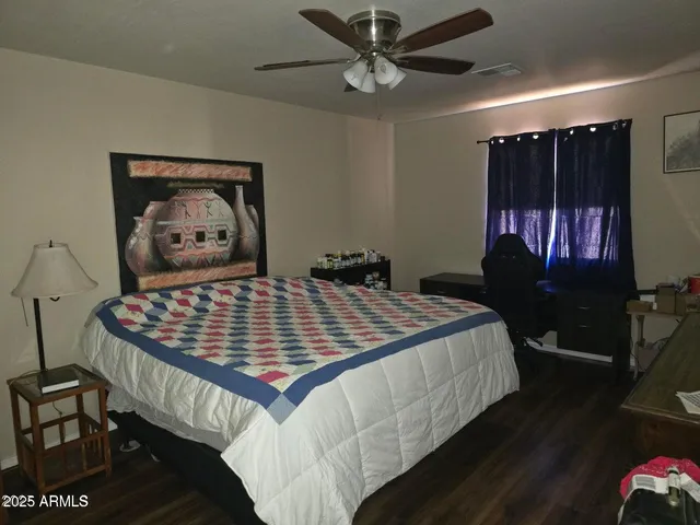 a bedroom with a bed and a painting on the wall