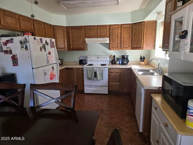a kitchen with a white stove top oven and refrigerator