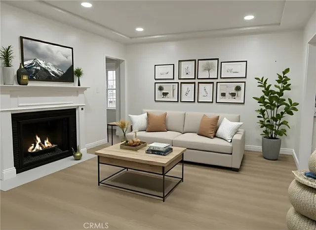a view of an empty room with wooden floor and a fireplace