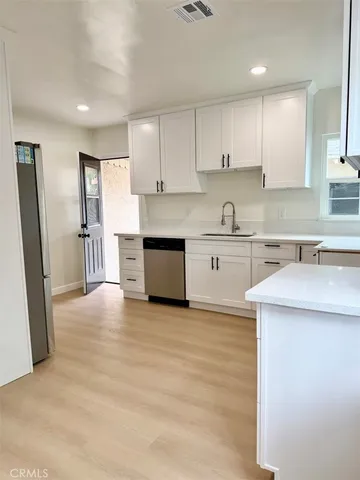 a kitchen with granite countertop white cabinets and white appliances