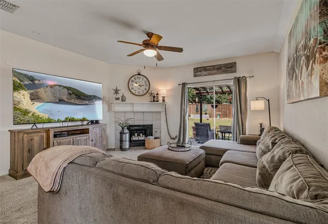 a living room with furniture a fireplace and a large window