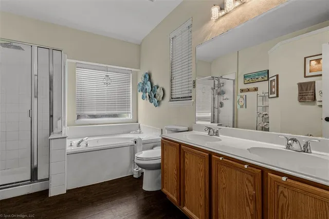 a bath room with a sink vanity granite and toilet