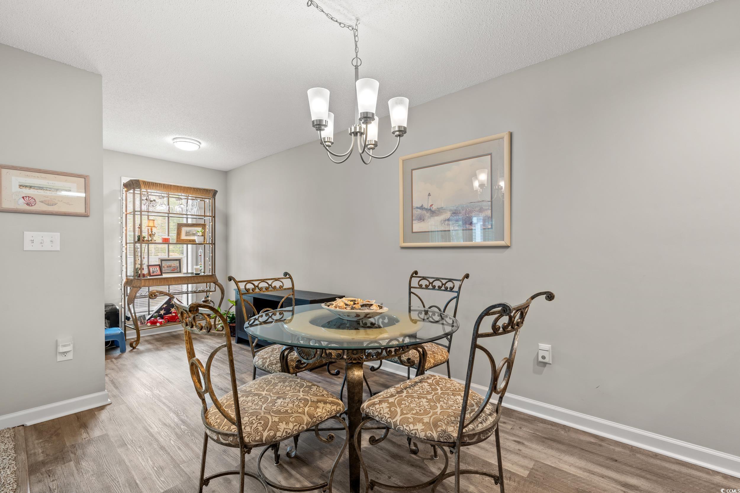 14 Laurel Street, Unit 14 Conway, SC 29526 - Photo 11 of 40 Dining space featuring a chandelier, wood finished floors, and a textured ceiling