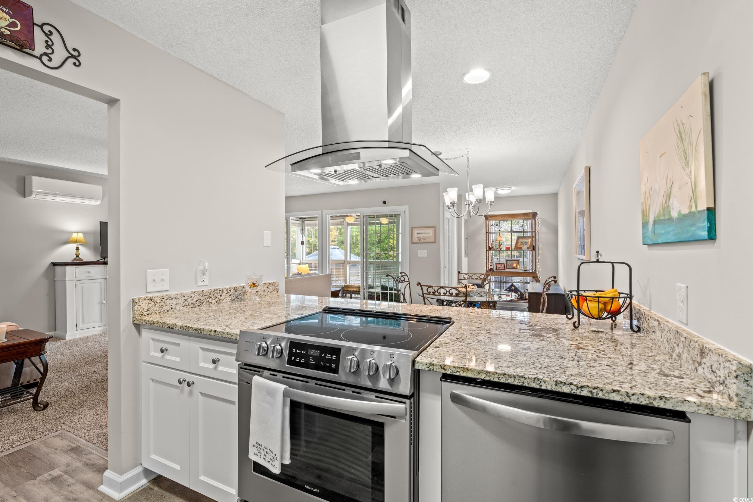 14 Laurel Street, Unit 14 Conway, SC 29526 - Photo 14 of 40 Kitchen featuring appliances with stainless steel finishes, island range hood, light stone counters, white cabinetry, and a textured ceiling