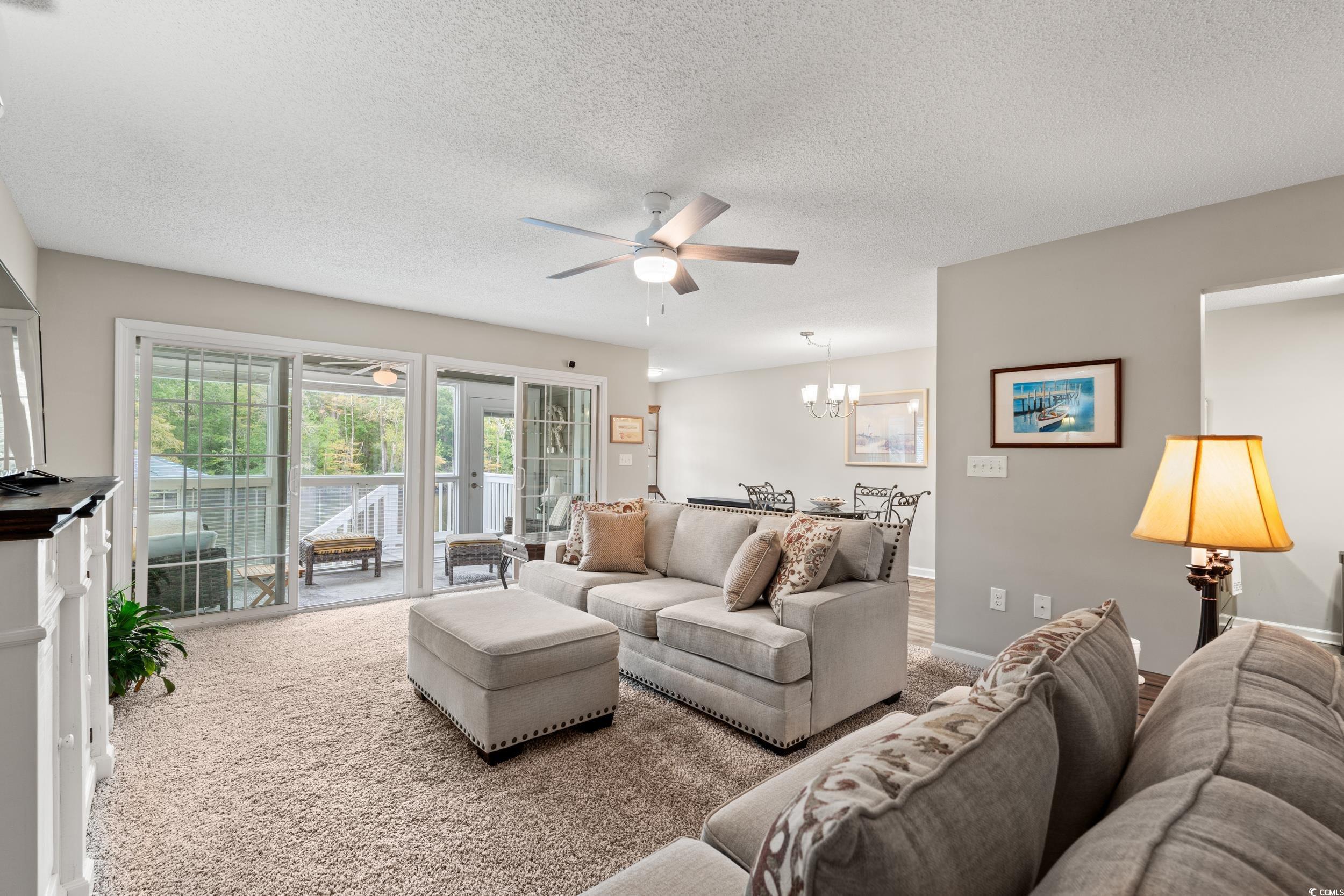 14 Laurel Street, Unit 14 Conway, SC 29526 - Photo 3 of 40 Living room with ceiling fan, a textured ceiling, a chandelier, and carpet flooring