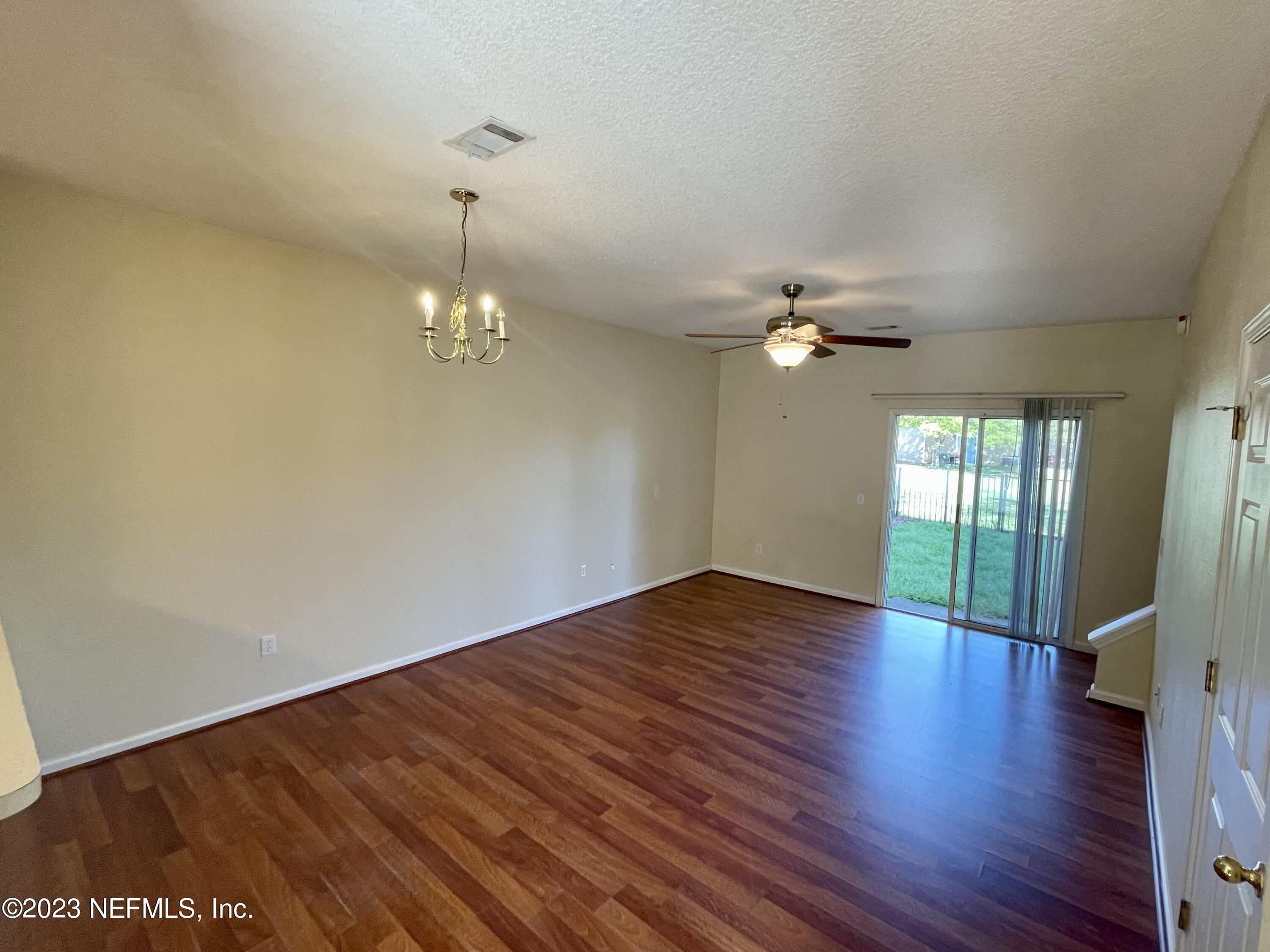 938 Scrub Jay Drive St. Augustine, FL 32092 - Photo 5 of 13 a view of a livingroom with wooden floor a ceiling fan and windows