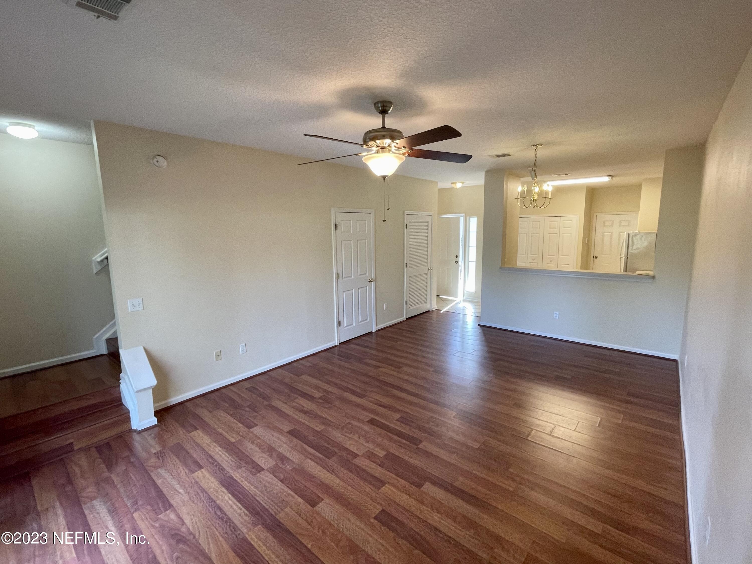 938 Scrub Jay Drive St. Augustine, FL 32092 - Photo 7 of 13 a view of an empty room with wooden floor and a ceiling fan