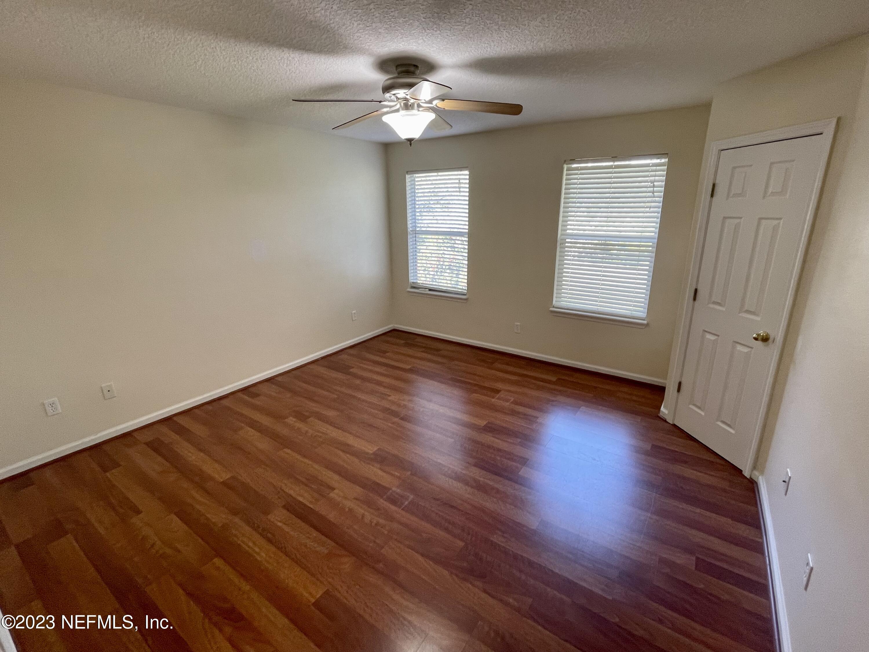 938 Scrub Jay Drive St. Augustine, FL 32092 - Photo 8 of 13 wooden floor in an empty room with a window