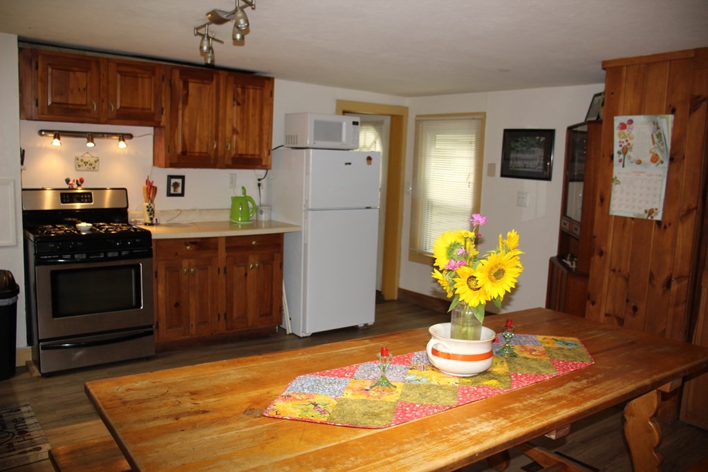 3 York Road Colrain, MA 01340 - Photo 11 of 37 a kitchen with stainless steel appliances granite countertop a refrigerator a stove a sink dishwasher and microwave with wooden floor