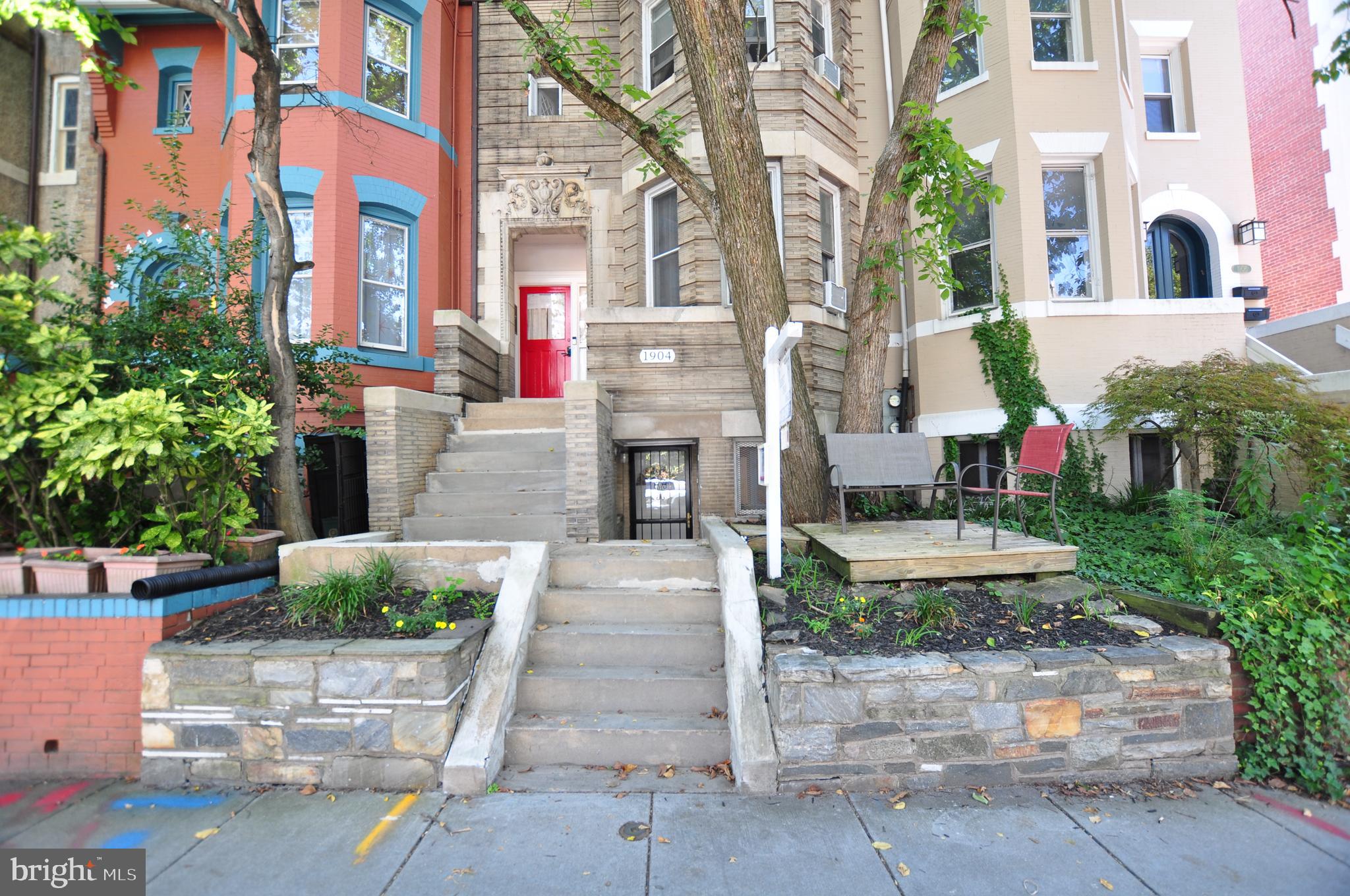 1904 Calvert Street Northwest Washington, DC 20009 - Photo 1 of 13 a front view of a multi story residential apartment building with yard and sign board