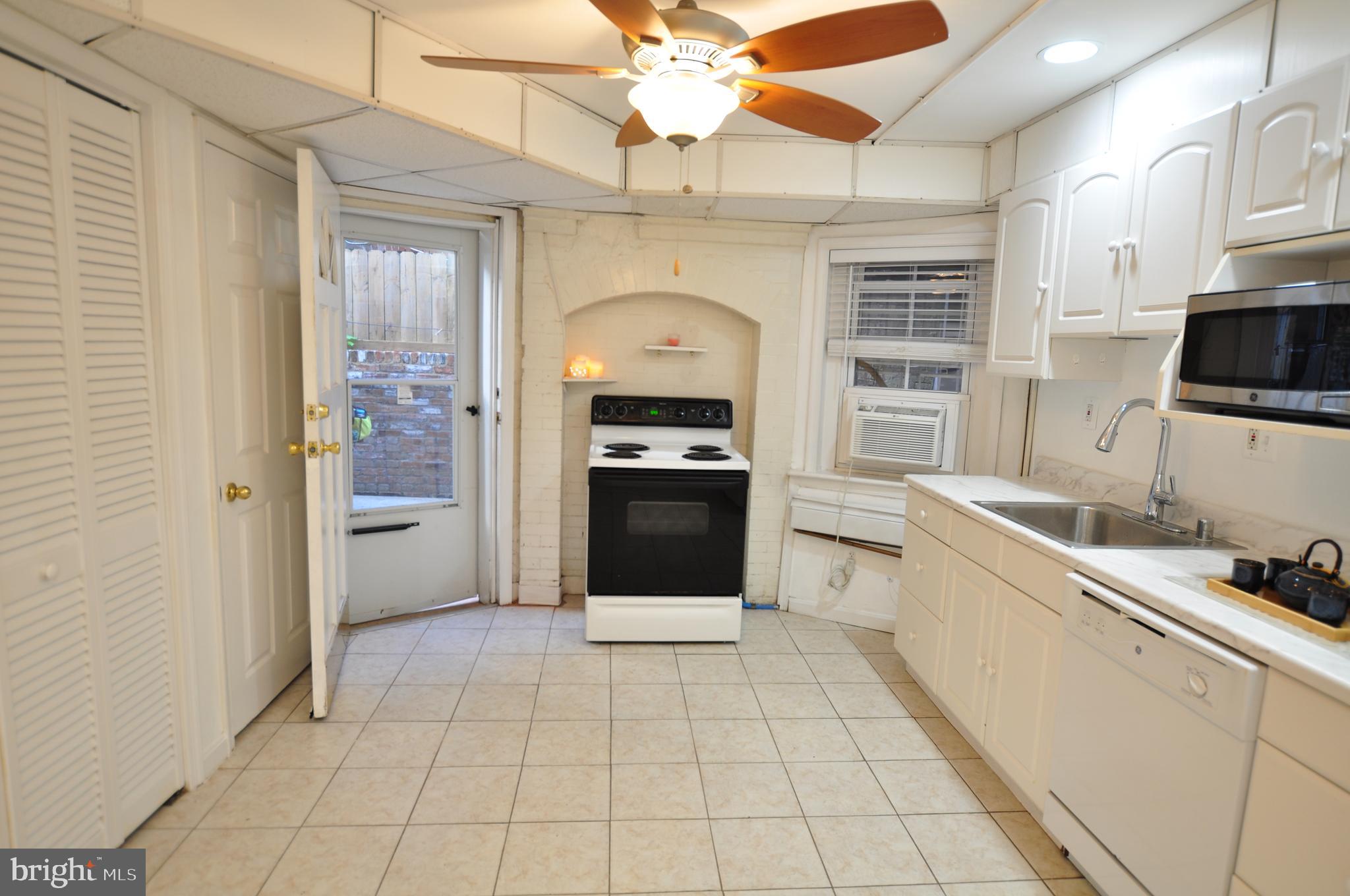1904 Calvert Street Northwest Washington, DC 20009 - Photo 7 of 13 a kitchen with a sink a stove and cabinets
