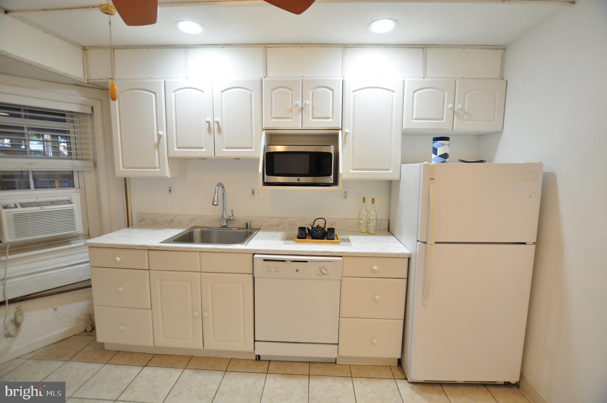 1904 Calvert Street Northwest Washington, DC 20009 - Photo 8 of 13 a utility room with cabinets washer and dryer