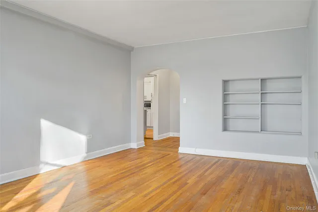 an empty room with wooden floor and cabinet