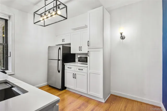 a kitchen with white cabinets and stainless steel appliances