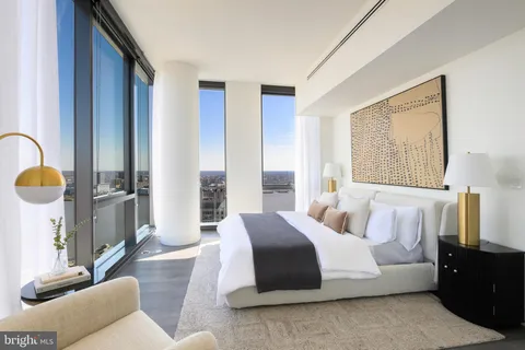 a spacious bedroom with a bed a couch and dresser