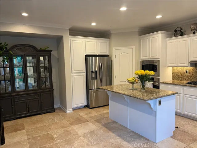 a kitchen with stainless steel appliances granite countertop a refrigerator and a sink