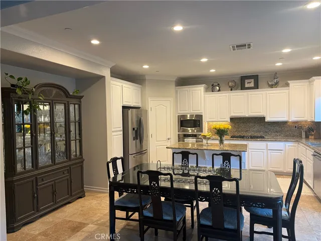 a kitchen with refrigerator and chairs