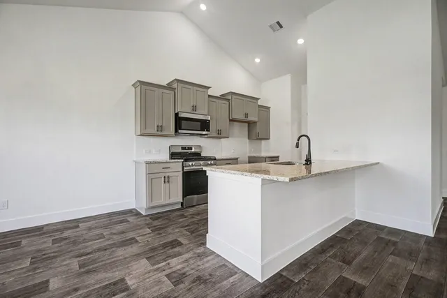 a kitchen with appliances a sink and cabinets