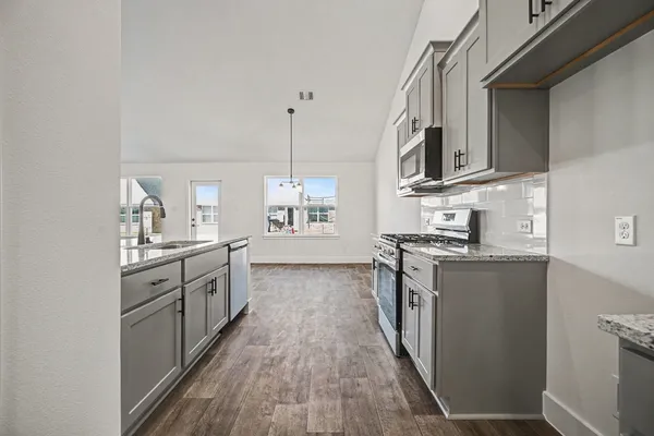 a large kitchen with stainless steel appliances granite countertop a stove and a sink