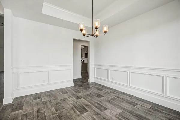 a view of a room with wooden floor and chandelier